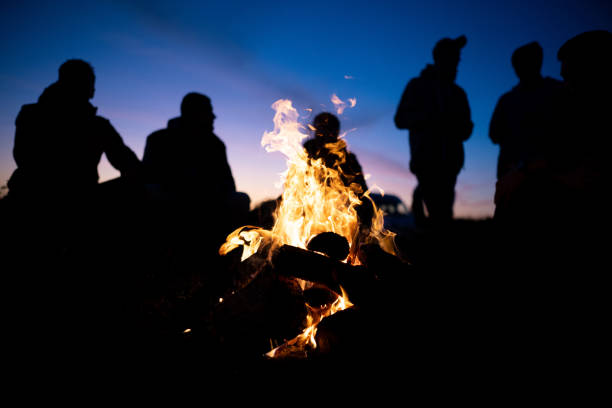 A small crew around a fire after a long day
